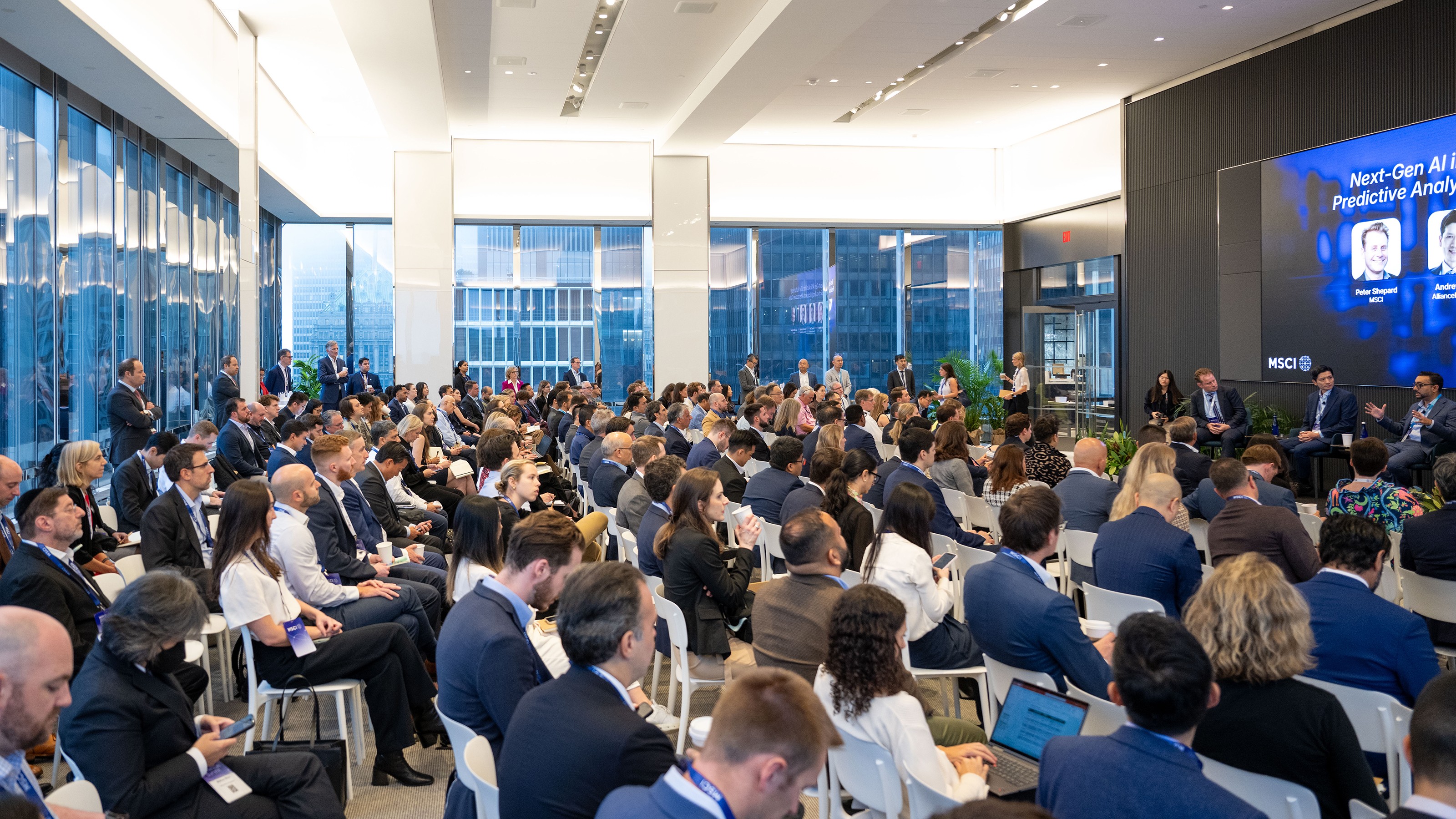 A large audience seated and listening to a panel on predictive analytics at an MSCI conference.