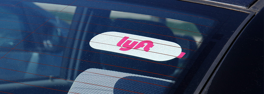 A car's rear window with a LYFT sticker in it