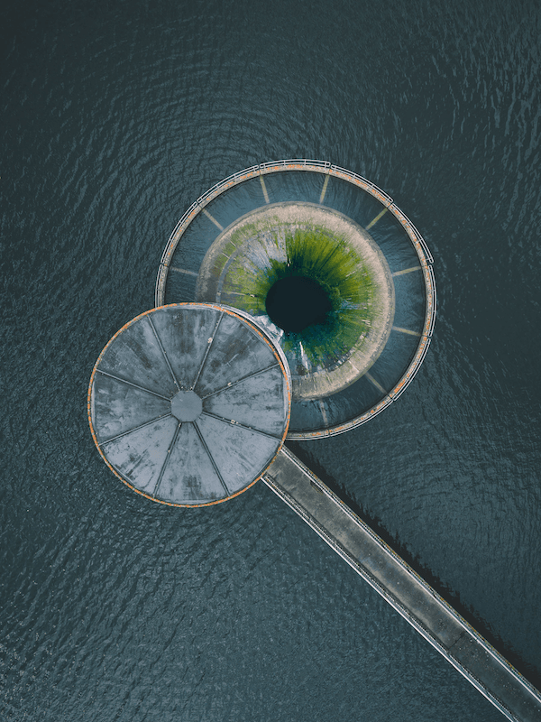 Mountains featuring a road, greenery and blue skies, leading to the topic of MSCI ESG and Climate index performance.